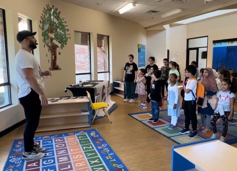 Yusuf teaching Middle Eastern folklore dance to a room of students